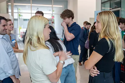 decorative image of people talking at a campus event